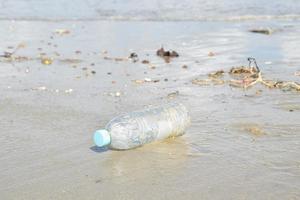 Verschmutzungen und Flasche am Strand von Menschen foto