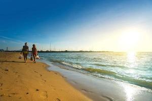 nicht identifizierte ausländische touristen tragen bikinis spazieren am strand sand pattaya thailand.