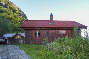 Alte braune Holzhütte mit einem geparkten Auto, Norwegen. foto