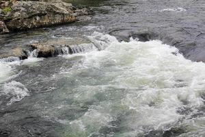 fließender schöner türkisfarbener flusssee mit steinen in hemsedal, norwegen. foto