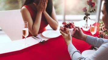 mann paar hand halten ein romantisches geschenk rote geschenkbox geben es an freundin. foto