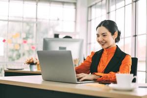 Porträt der asiatischen eleganten Frau des Büroarbeitsgeschäfts. moderner arbeitstisch mit dokumenten-laptop-computer. foto