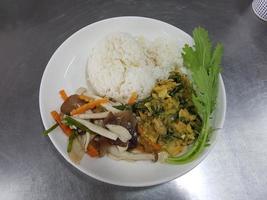 thailändisches essen auf einem weißen teller, grünes gemüse, pilze, muscheln, lichtschein. foto