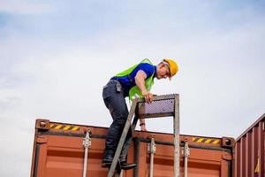 Arbeiter klettern die Leiter zum Container hinauf foto