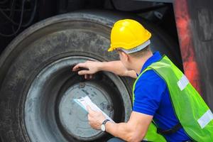 Mechaniker prüfen Rad im Frachtcontainer. professioneller techniker prüft gabelstaplerreifen vor, sicherheitskonzept. foto