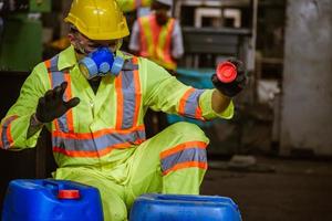 ingenieurindustrie, die sicherheitsuniform, schwarze handschuhe und gasmaske trägt, fühlt sich erstickt an, wenn sie den chemikalientank in der industriefabrikarbeit überprüft. foto