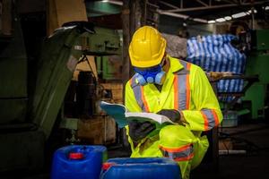 ingenieurindustrie, die sicherheitsuniform, schwarze handschuhe und gasmaske trägt, fühlt sich erstickt an, wenn sie den chemikalientank in der industriefabrikarbeit überprüft. foto