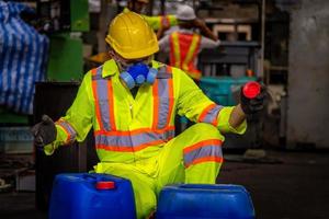 ingenieurindustrie, die sicherheitsuniform, schwarze handschuhe und gasmaske trägt, fühlt sich erstickt an, wenn sie den chemikalientank in der industriefabrikarbeit überprüft. foto