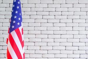 Nahaufnahme der amerikanischen Flagge vor weißem Backsteinmauerhintergrund foto