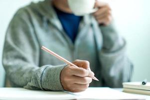 schreiben auf papier bei der arbeit morgens auf dem tisch, geschäftsideen. Platz zum Kopieren ist vorhanden. foto