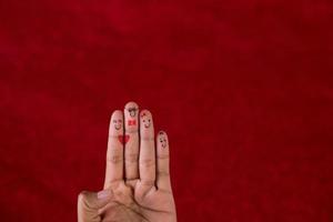 Roter Hintergrund und Finger und süßes Lächelnkunstkonzept foto