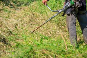 Arbeiter, der das Gras mäht foto