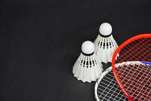 Cremeweißer Badmintonfederball und Schläger mit Neonlichtschattierung auf grünem Boden im Indoor-Badmintonplatz, verschwommener Badmintonhintergrund, Kopierraum. foto