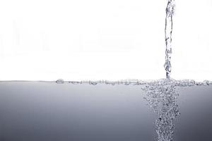 Wasserströmungsoberfläche mit Luftblasen lokalisierter weißer Hintergrund. foto