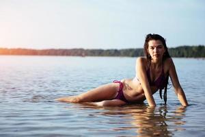 junges schönes Mädchen, das am Strand posiert foto