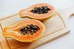 exotische Frucht Papaya oder Papaya isoliert auf weißem Hintergrund auf Holzbrett. gesunde ernährung diät essen. foto