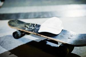 Skateboard mit Brille und Mütze am Abend im Skatepark. foto