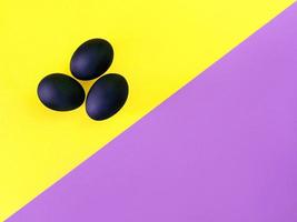 schwarze Eier auf dem gelben und violetten Hintergrund. ostern, vielfalt, geometrisch, muster, lebensmittelkonzept foto