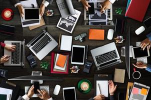 Draufsicht der Geschäftsgruppe von multiethnischen beschäftigten Menschen, die sich mit anderen in einem modernen Büro mit Laptop-Computer treffen, foto