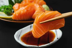 Sashimi, Lachs, japanische Essstäbchen und Wasabi foto