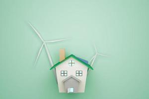 Hausmodell und Windkraftanlagen auf grünem Hintergrund, Umweltkonzept foto