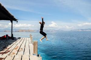 aufgeregte Frau, die ins Wasser springt foto