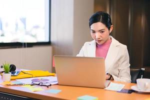 porträt der asiatischen arbeitenden eleganten frau des bürogeschäfts mit computer. foto