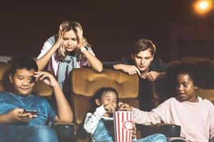 erwachsene menschen ärgern eine laute kindergruppe im kino. foto