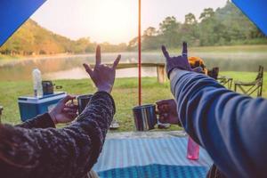 der blick ins zelt des paares ist beim morgendlichen kaffee sitzen. paar reisen camping zelte, reisen natur. reise entspannen, campingsee in thailand. foto