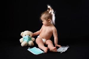ein kleines kind sitzt neben einem kranken teddybären. das Konzept foto