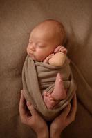 neugeborenes mädchen, das mit einem getrockneten herzen in ihren händen schläft. foto