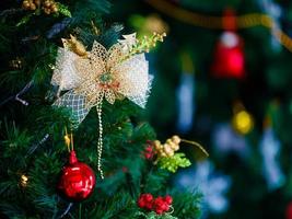 Stoffverzierungsschleife, die am Weihnachtsbaum hängt, mit Kopienraum auf der rechten Seite foto