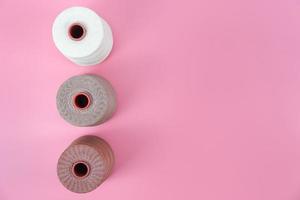 Draufsicht mit Kopierraum der gewachsten Seilgruppe in weißer und brauner Farbe oben auf rosafarbenem Pastellhintergrund, Lederhandwerk oder Lederarbeitsflachkonzept foto