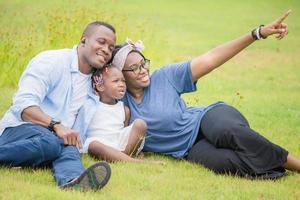 glücklicher vater, mutter und tochter, die zusammen im freien spielen, fröhliche afroamerikanische familie, die im park genießt, glücksfamilienkonzepte foto