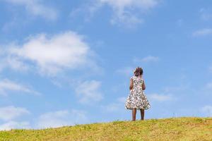 Afroamerikanerkindmädchen, das draußen mit blauem Himmelshintergrund spielt foto