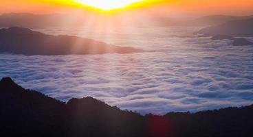 schöne landschaftsansicht des sonnenaufgangs-berggipfels mit tropischem wald im nebel. Panoramablick auf ein Bergtal in niedrigen Wolken foto