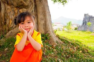 Schönes kleines Mädchen trägt gelb-orangees Outfit Gokowa-Outfit, Mugunghwa in einem öffentlichen Park. Modekleid für Mädchen und Teenager. foto