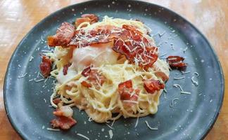 Carbonara-Spaghetti mit Onsen-Ei, knusprigem Speck, hartem Parmesankäse und Sahnesauce. foto