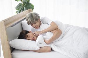 ein männliches paar mit einem asiatischen mann schläft zusammen in einem bett, ein symbol für sexuelle vielfalt, das offen schwule männer ausdrückt, die lgbt-konzepte akzeptieren. foto