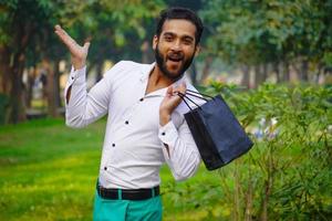 indischer mann mit schwarzen einkaufen zurück aufgeregt zum einkaufen foto