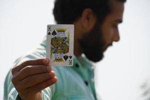 mann mit spielkarten, die königskarte zeigen - pokerkonzept foto