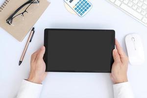 Draufsicht auf minimalen Arbeitsplatz mit digitalem Tablet, Smartphone, Tastatur und Papier auf weißem Schreibtisch. foto