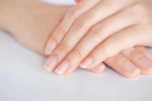 Nahaufnahme der schönen Hände und Fingernägel der Frau auf weißem Hintergrund, Konzept der Gesundheitsversorgung des Fingernagels. foto