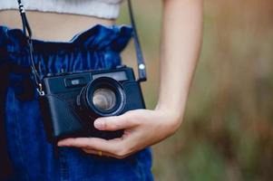 Hand und Kamera des Fotografen, der die Kamera hält und trägt, um Bilder aufzunehmen foto