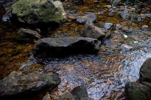 natürlicher Wasserfall, Schulterfluss, durch die Spitze des Berges foto