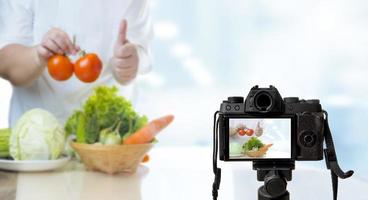 Fettleibige Bloggerin, die zu Hause in der Küche ein Video über gesunde Ernährung für übergewichtige Menschen aufzeichnet foto