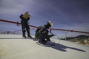 männliche zwei Arbeiter sind für die Inspektion von Ultraschalldicken-Dachplatten-Dome-Top-Tanks foto