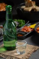 Soju-Flaschen und koreanische Beilagen auf der Speisekarte foto