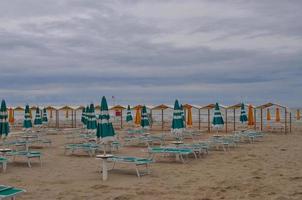 Uferstrand mit Sonnenschirm und Liegestühlen foto