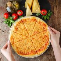 frauenhände nehmen pizza auf einem teller, draufsicht foto